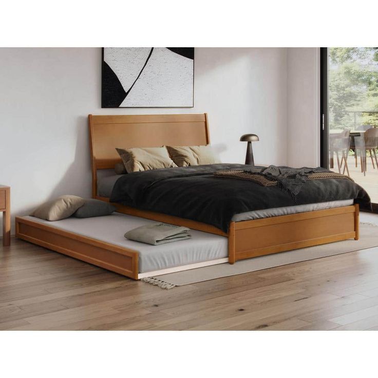 a bed that is sitting on top of a hard wood floor in front of a window