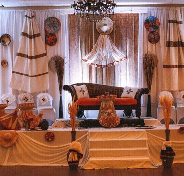 a living room filled with lots of furniture covered in white drapes and decorations on the walls