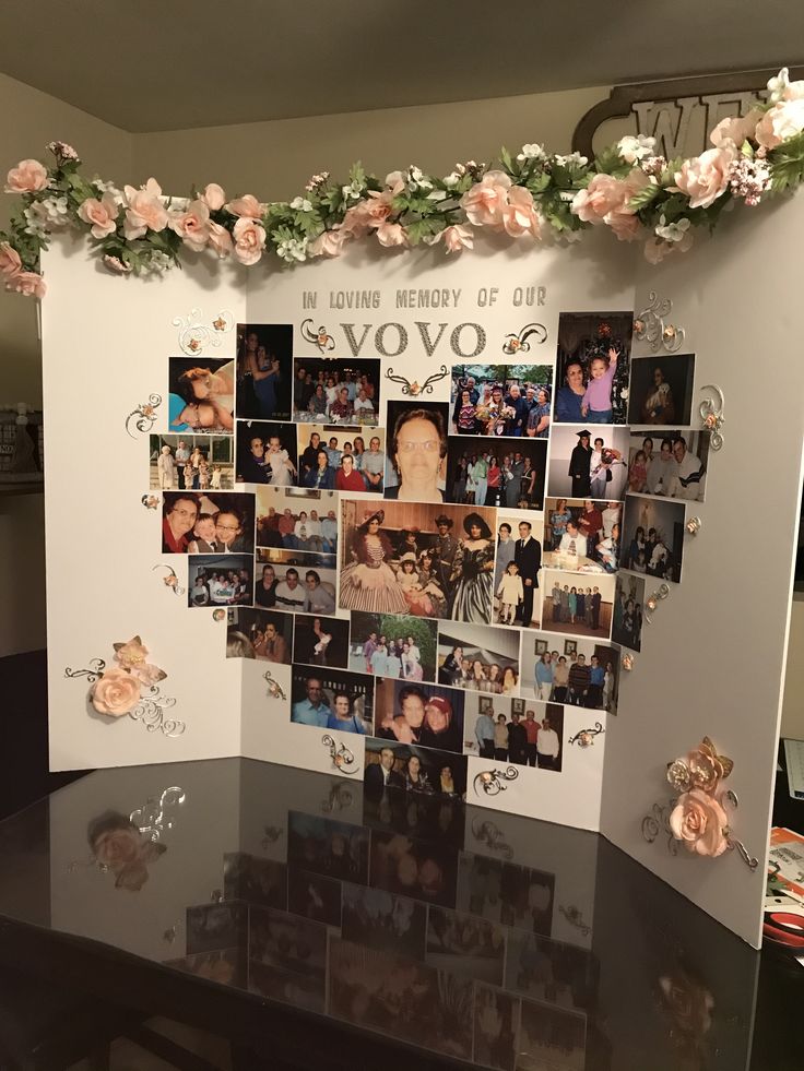 a table with pictures and flowers on it in front of a wall that says vovo