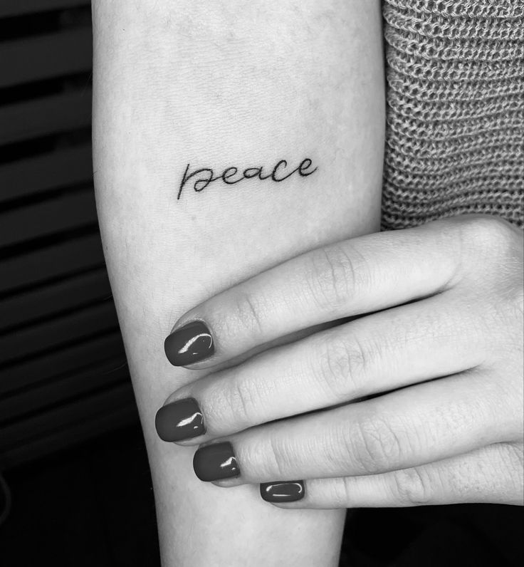 a woman's arm with the word peace tattooed on it