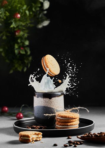 cookies are falling into a cup with milk