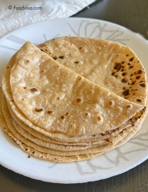 four tortillas are stacked on a white plate