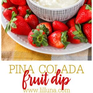 a white plate topped with strawberries next to a bowl of fruit dip