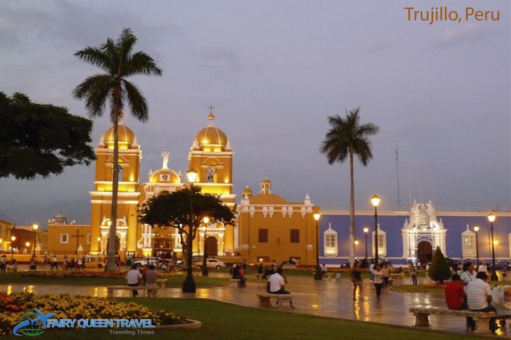 people are sitting on benches in front of a large yellow building with white domes and gold trim