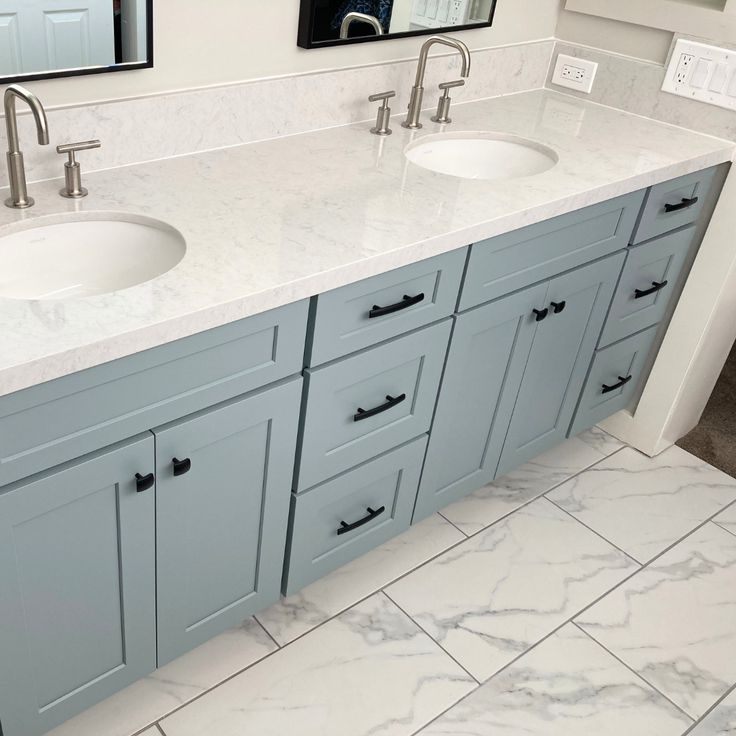 a bathroom with double sinks and marble counter tops