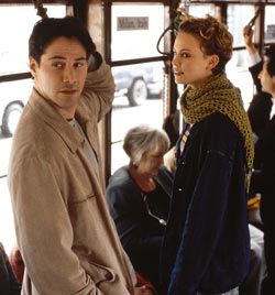 two people standing in front of a window next to each other on a city bus