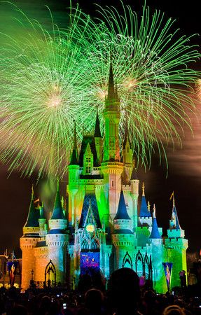 fireworks are lit up in the sky above a castle