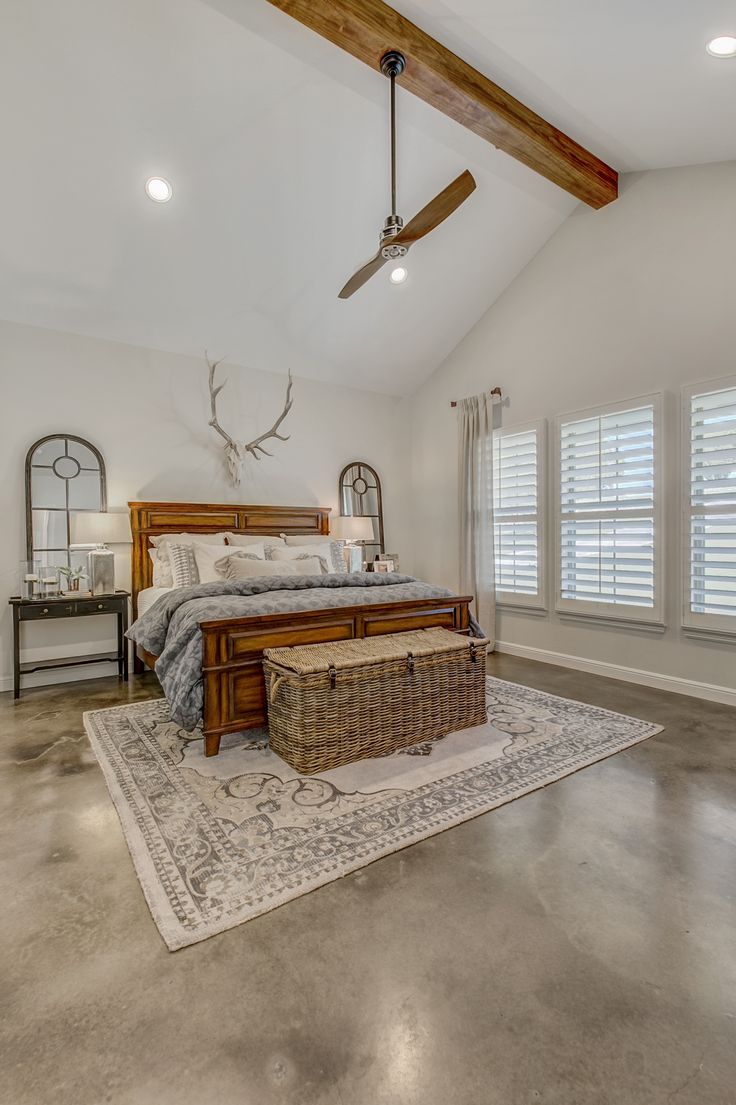 a bedroom with a bed, dresser and ceiling fan in the middle of the room