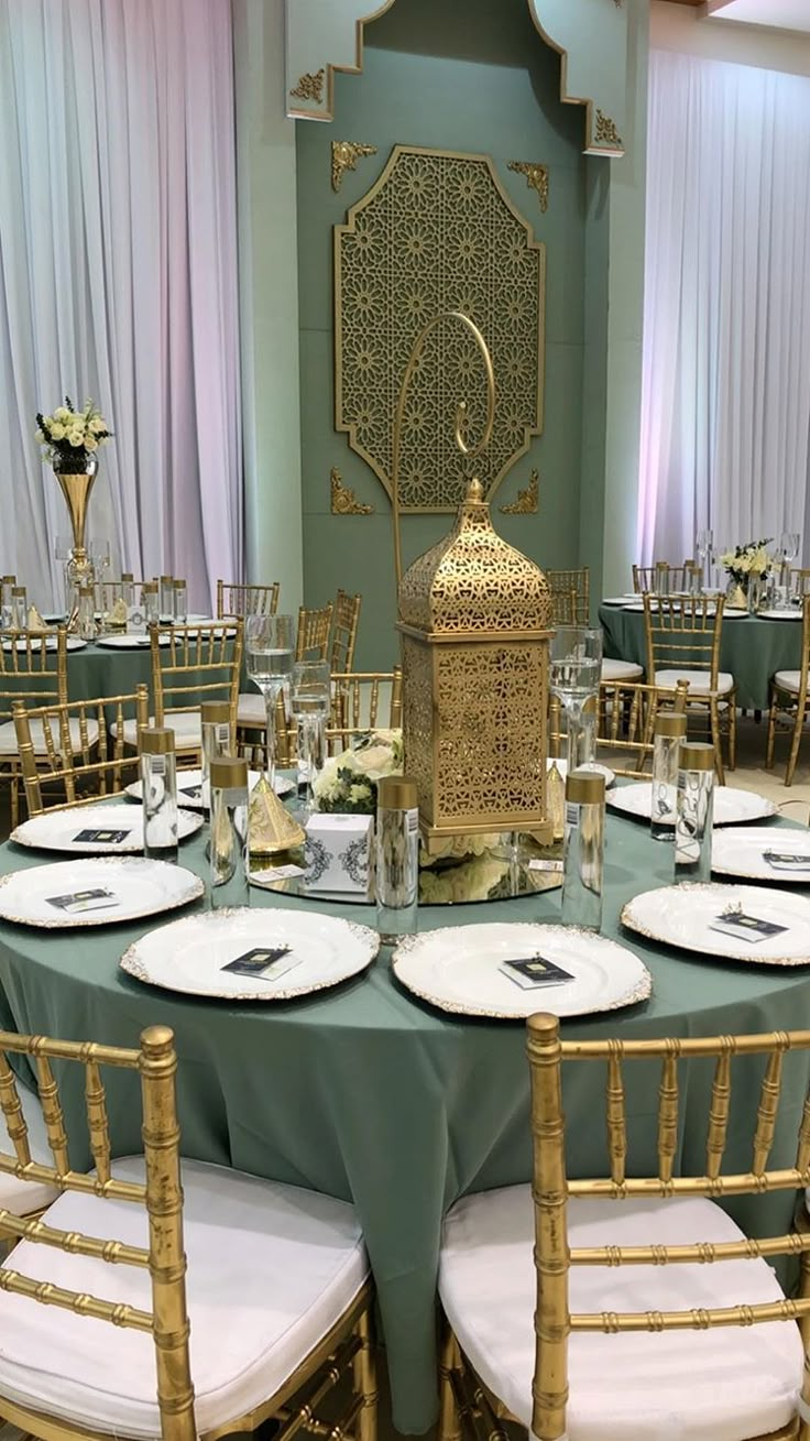 the table is set with plates, silverware and an ornate lantern on it's stand