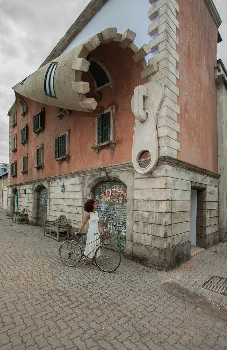 a woman on a bike in front of a building