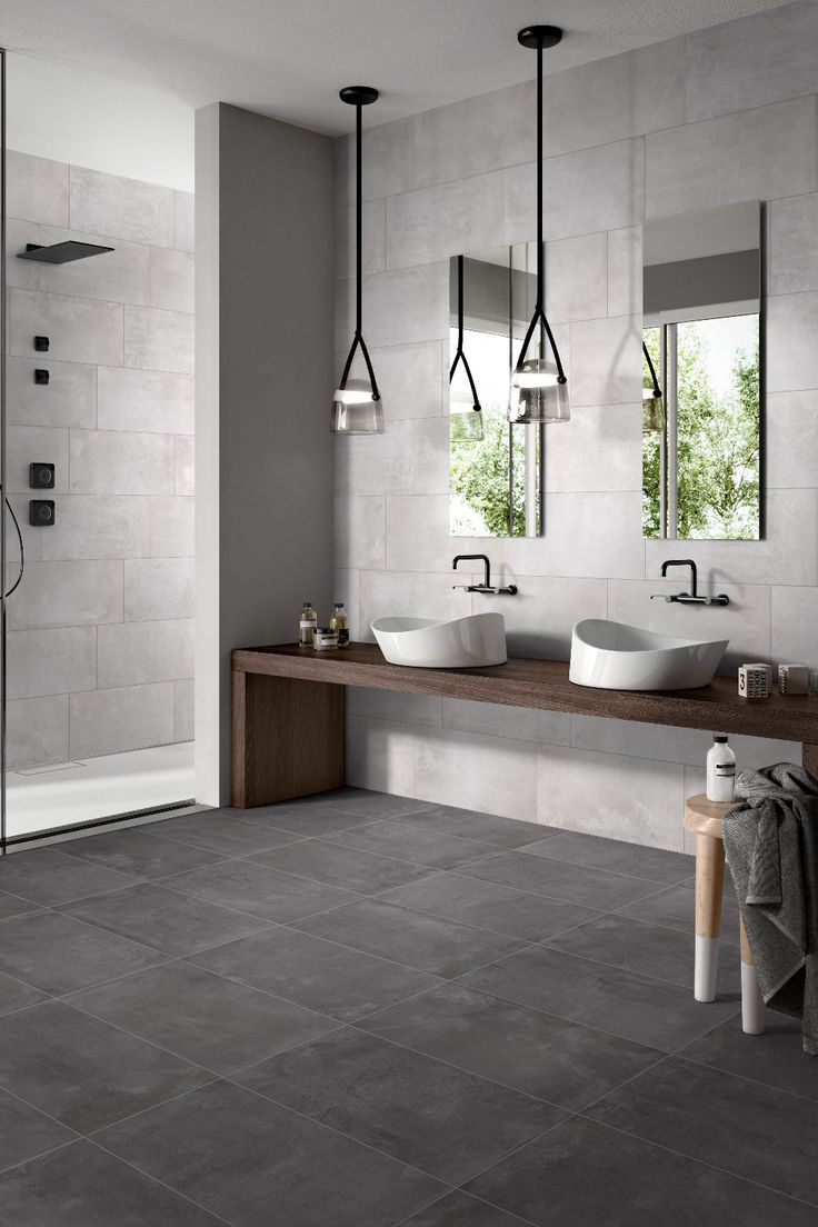 a bathroom with two sinks and mirrors on the wall, along with a walk in shower