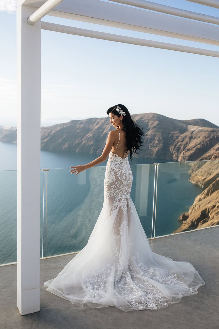 a woman in a wedding dress standing on a balcony