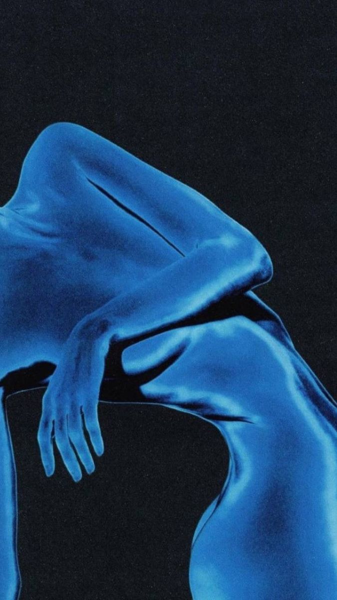 a woman's blue body is shown in this artistic photo, with her hands on her knees