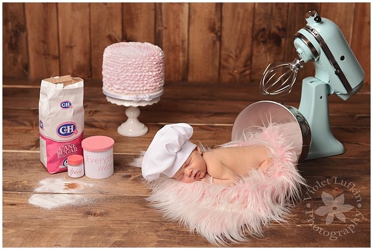 a baby is laying on the floor next to a cake mixer and other items that are around it