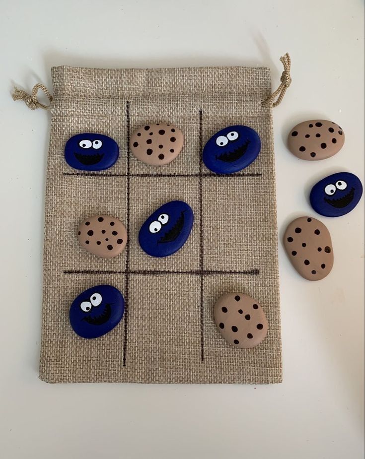 four rocks with eyes on them are placed in front of a bag that is made out of burlap