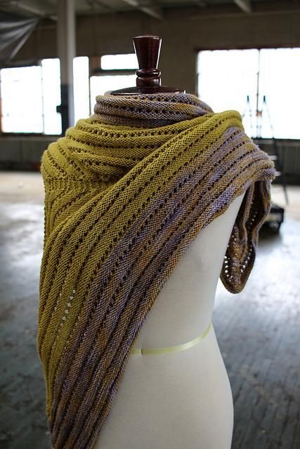 a white mannequin wearing a yellow and brown scarf on top of it's head