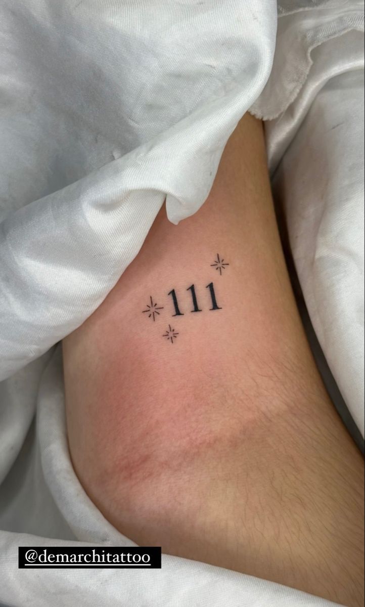 a woman's stomach with the number 11 tattooed on her lower leg and small snowflakes