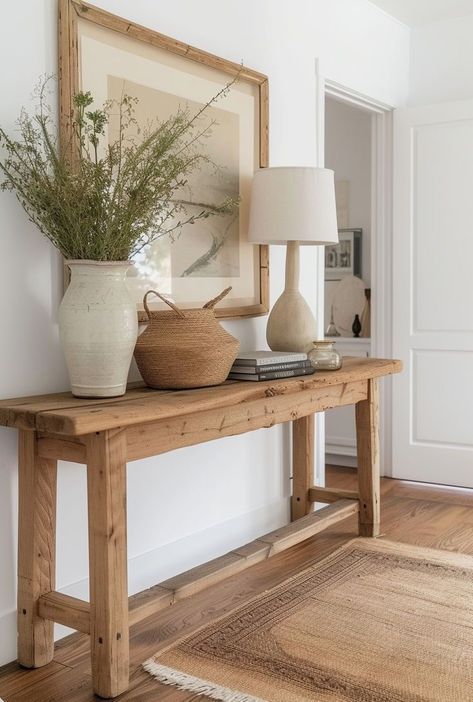 a wooden table with two vases on it and a lamp next to the table