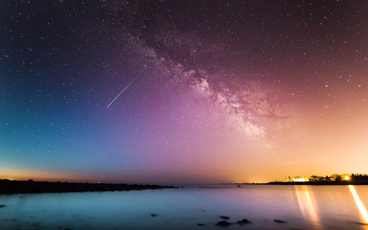 the night sky is filled with stars and bright lights as it reflects in the water