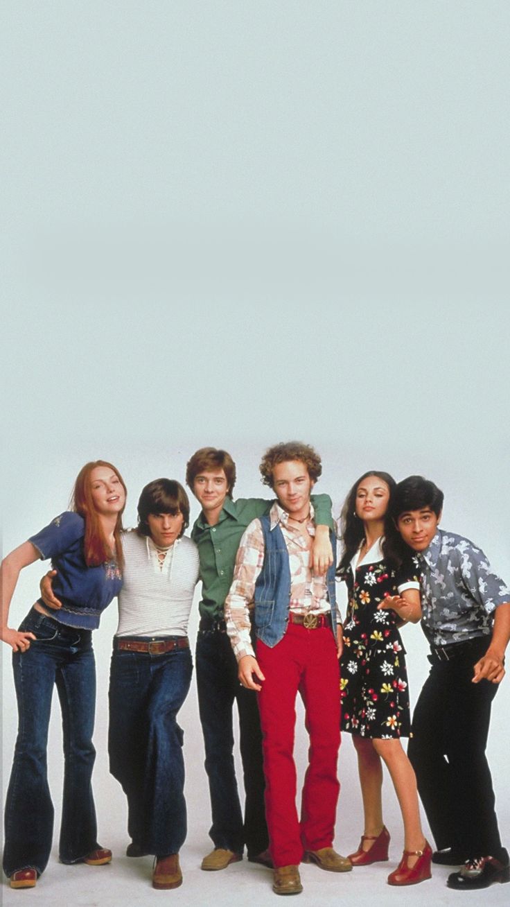 group of young people standing in front of a white background posing for the camera with their arms around each other