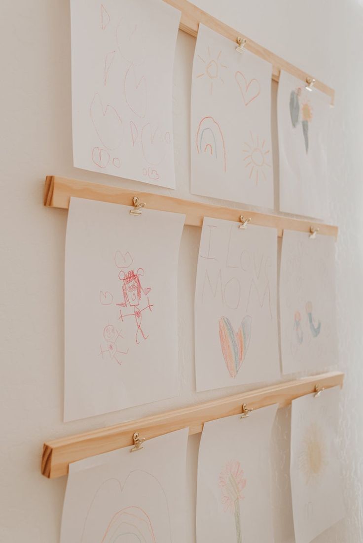 several children's drawings are hanging on the wall