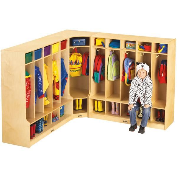 a child sitting in front of a wooden locker with lots of coats on the shelves