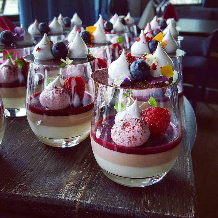 several desserts are arranged in small glasses on a table