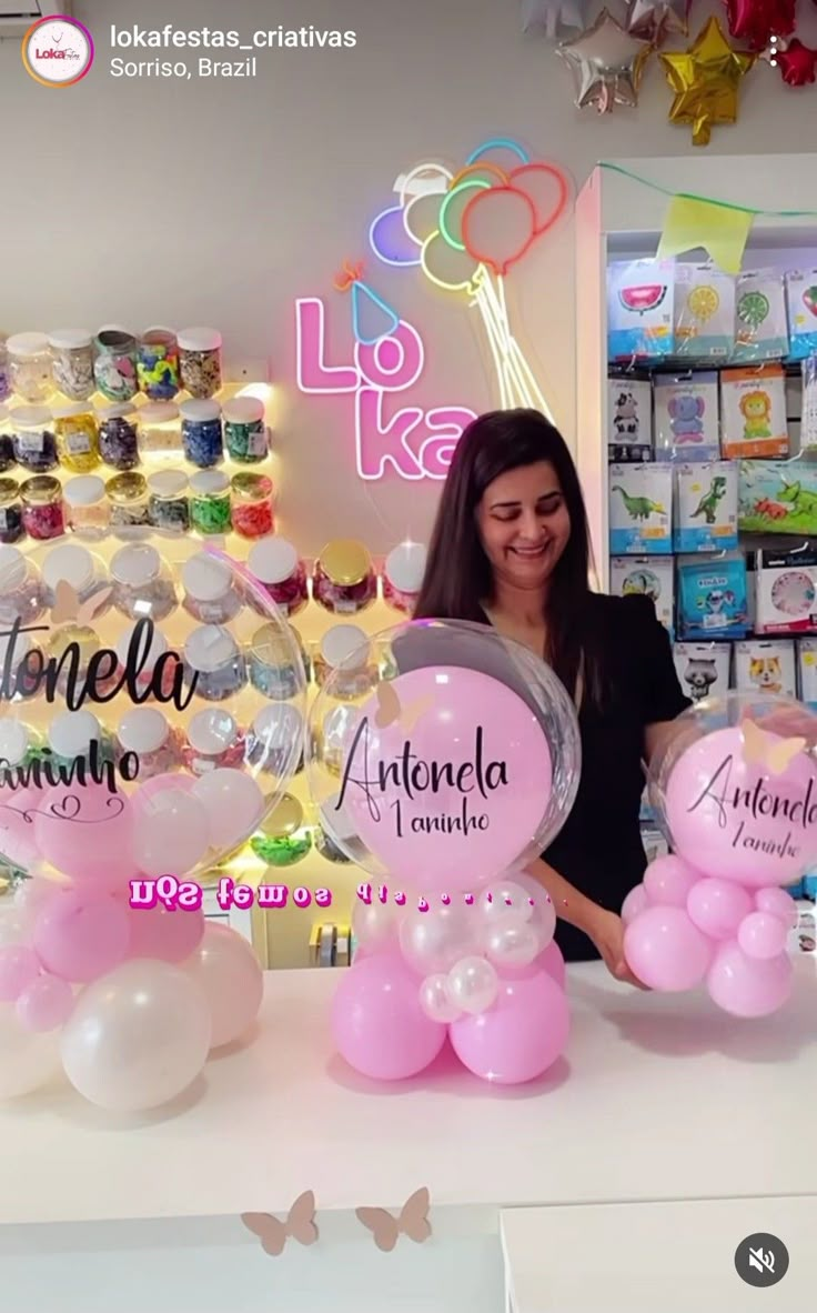 a woman standing behind a counter with balloons