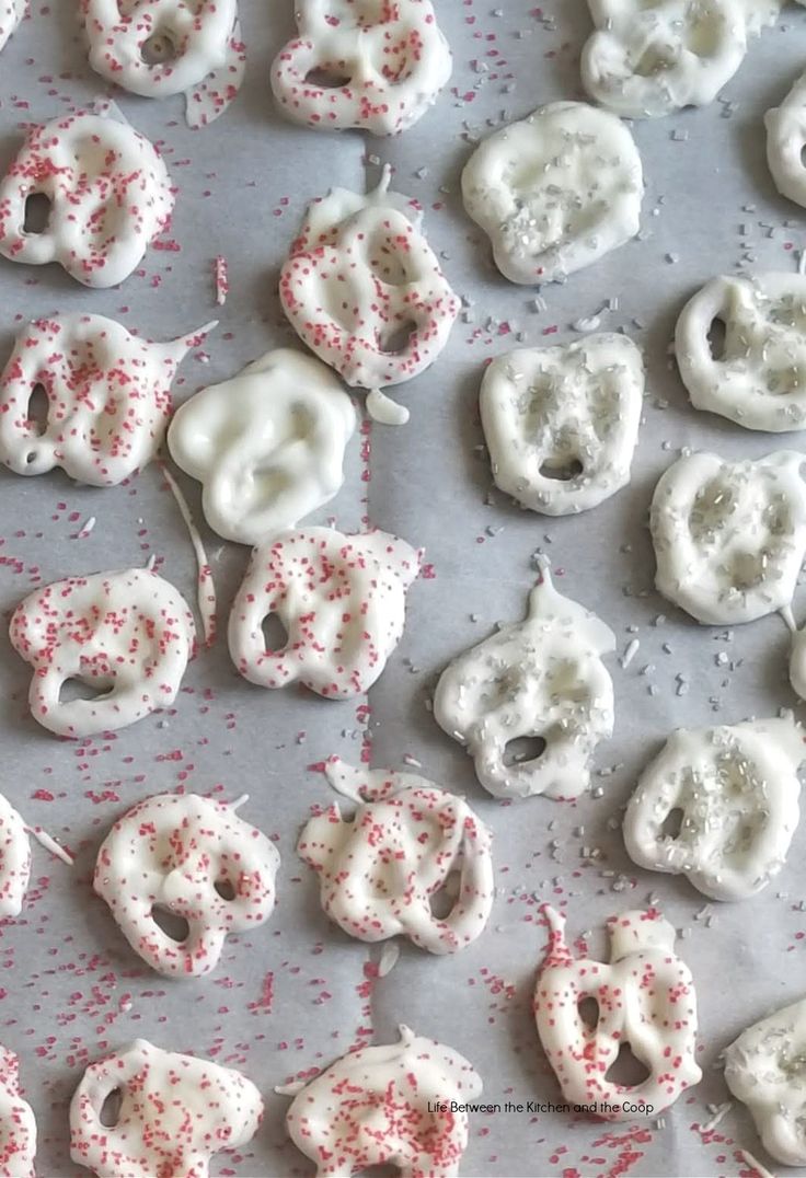 white and red sprinkled donuts are on a baking sheet, ready to be eaten