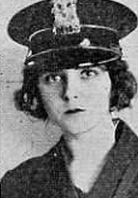 an old black and white photo of a woman wearing a hat with a cat on it