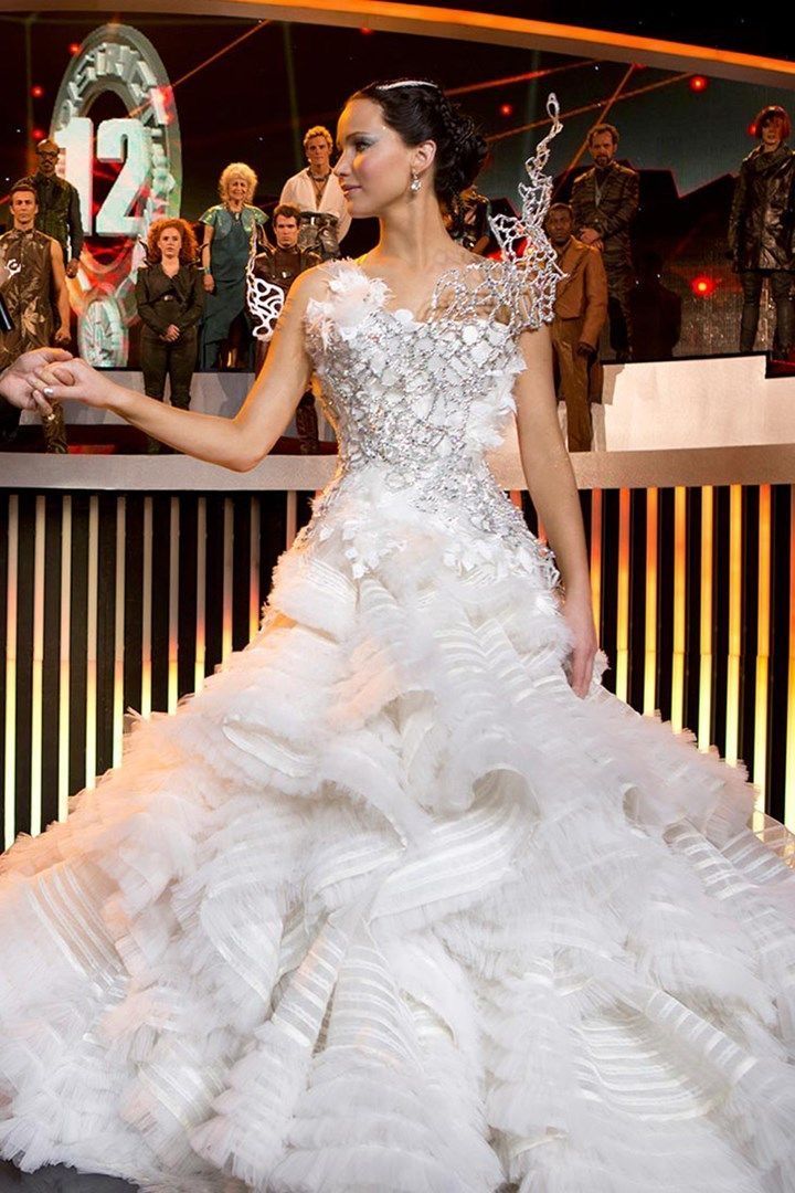 a woman in a white wedding dress standing on a stage