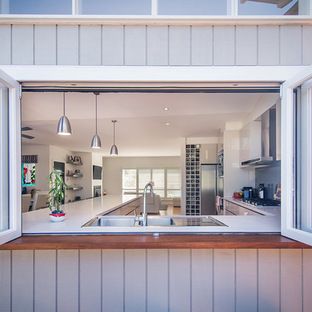 an open window shows the kitchen and living room in this home's new addition