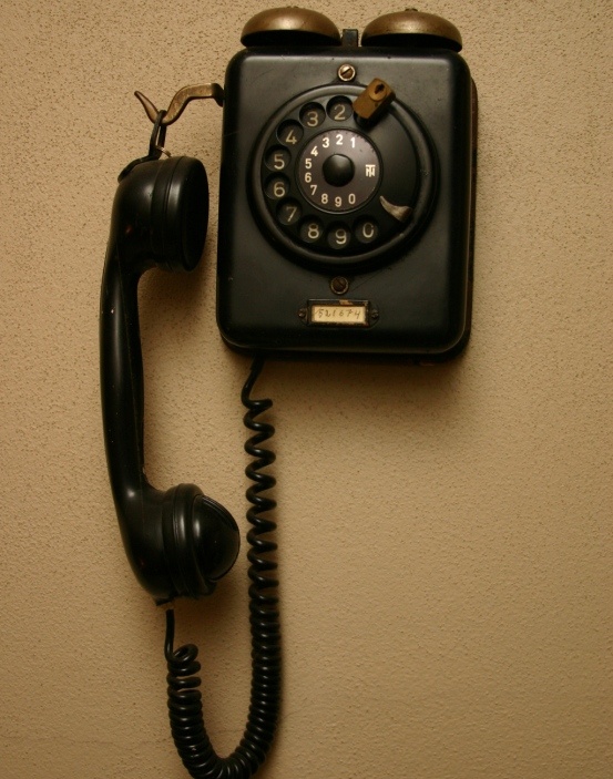 an old fashioned telephone is hanging on the wall