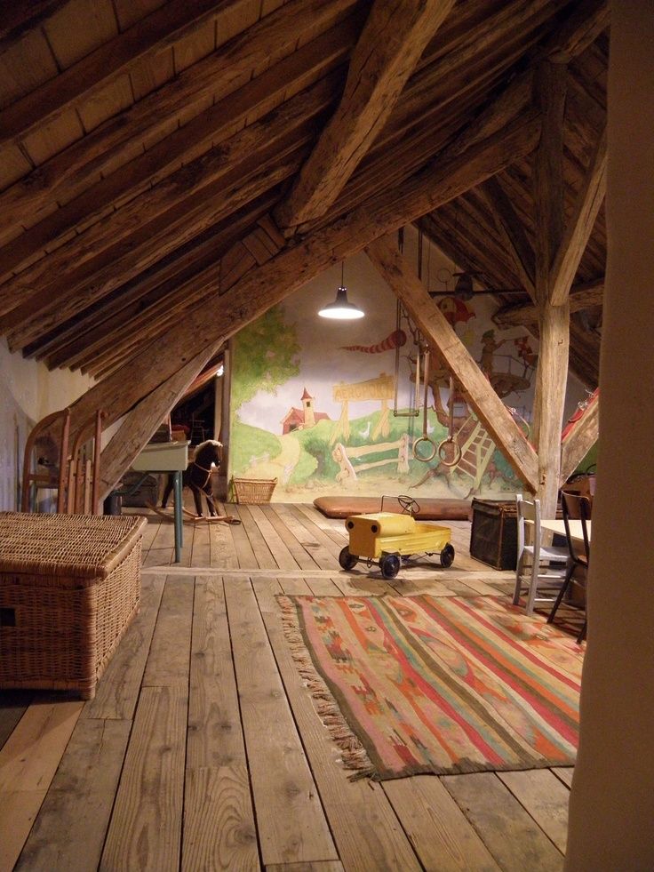 an attic with wood flooring and exposed rafters