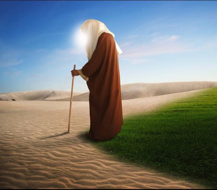 a person kneeling down in the sand with a light on their head and holding a stick