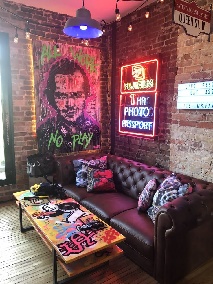 a living room with couches, tables and neon signs on the wall behind them