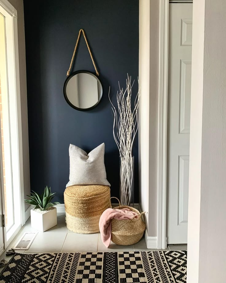 a black and white entryway with a round mirror on the wall next to a basket