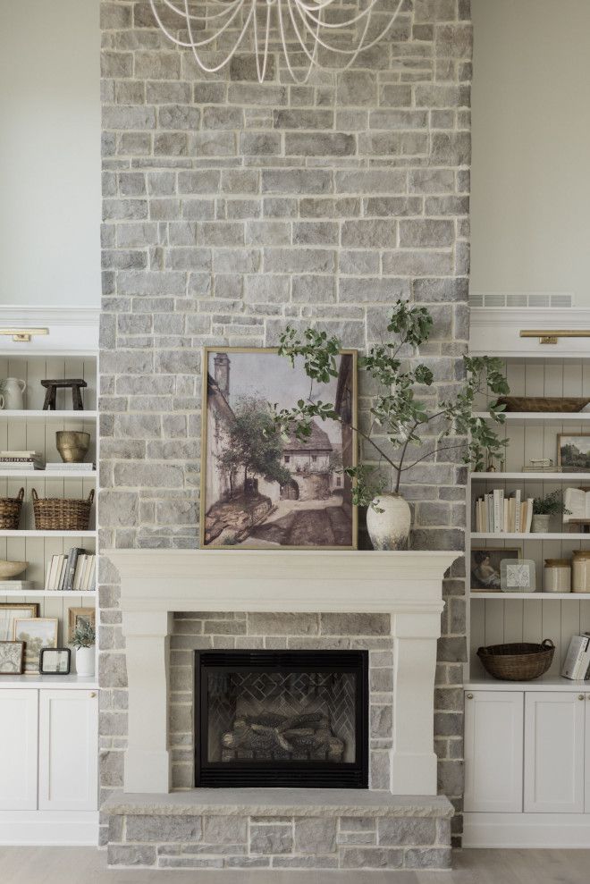 a living room filled with furniture and a fire place in front of a brick wall