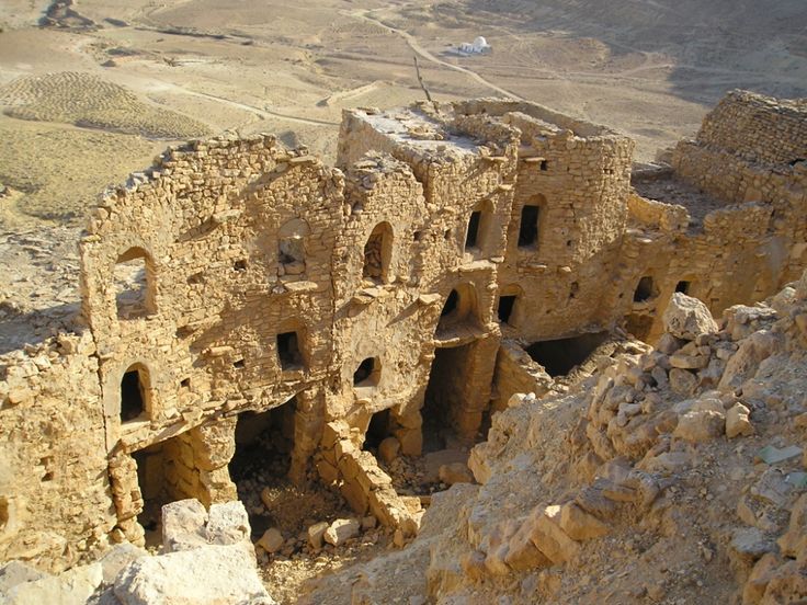 an old building that has been built into the side of a mountain with no people around it