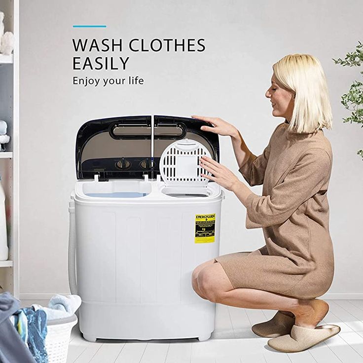 a woman kneeling down next to a washing machine