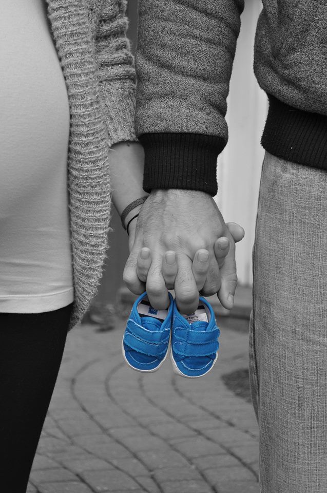 two people holding hands with blue shoes on them