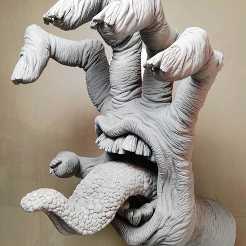 the sculpture is made to look like an animal's mouth and hands are open