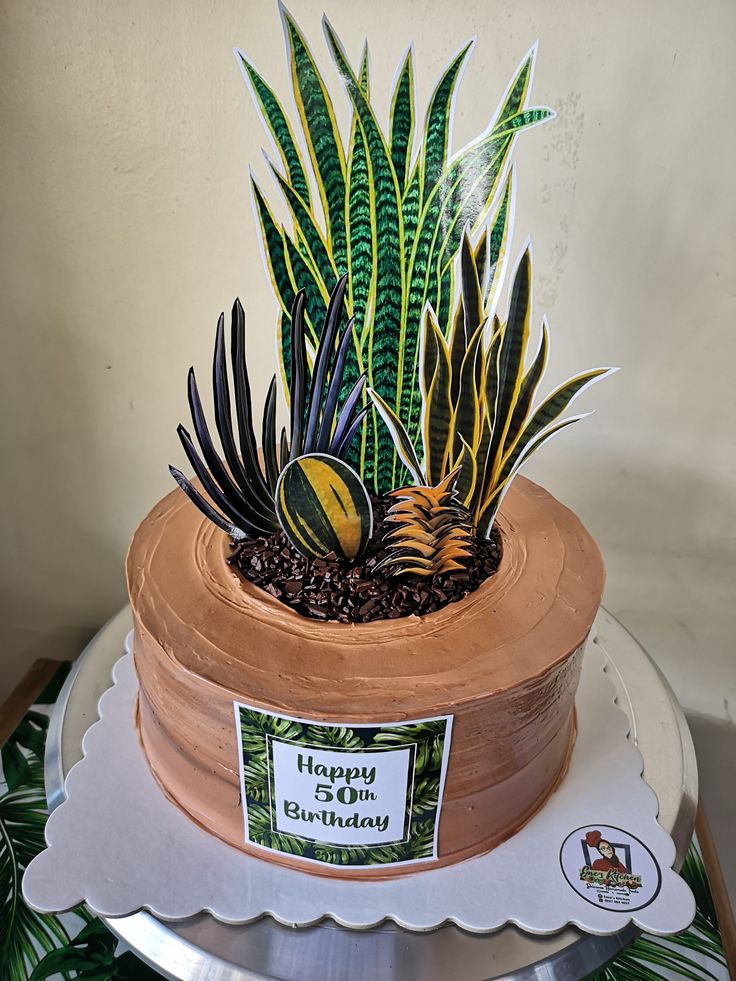 a cake decorated with plants on top of a table