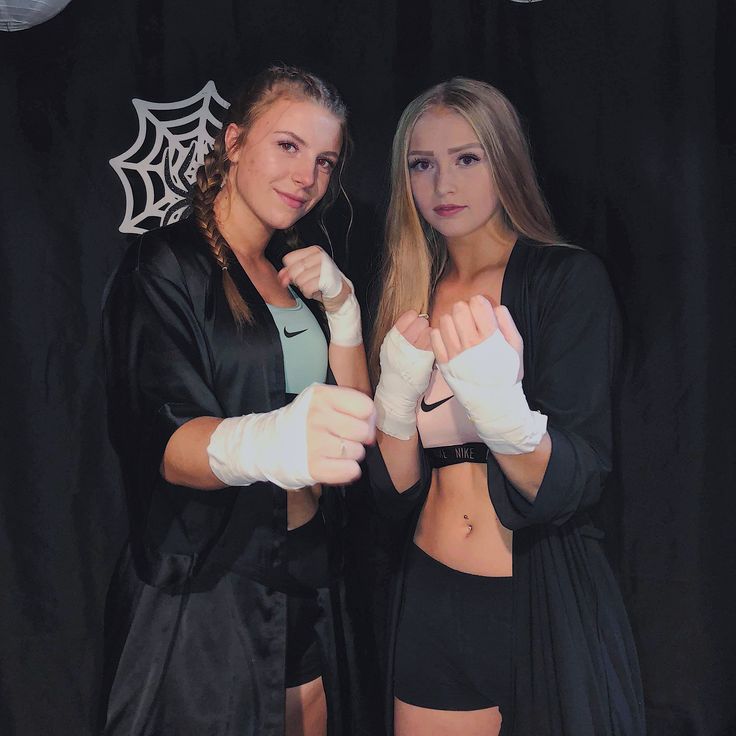 two beautiful young women standing next to each other wearing boxing gloves and holding white gloves