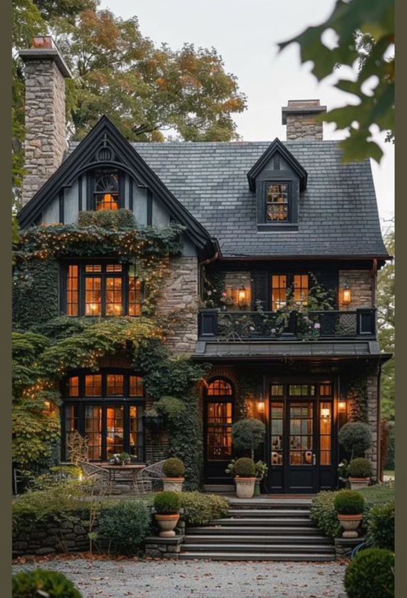 a large house with lots of windows and plants on the front porch, along with steps leading up to it