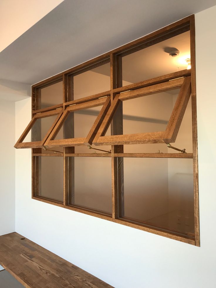 a wooden bench sitting under a window in a room