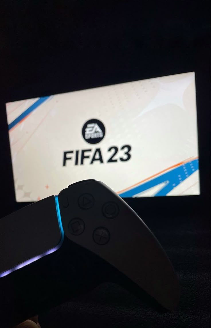 a video game controller sitting on top of a table next to a sign that says fifa 223