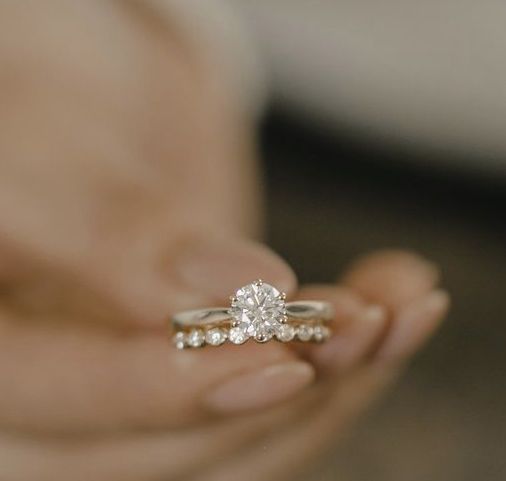 a person holding a diamond ring in their hand