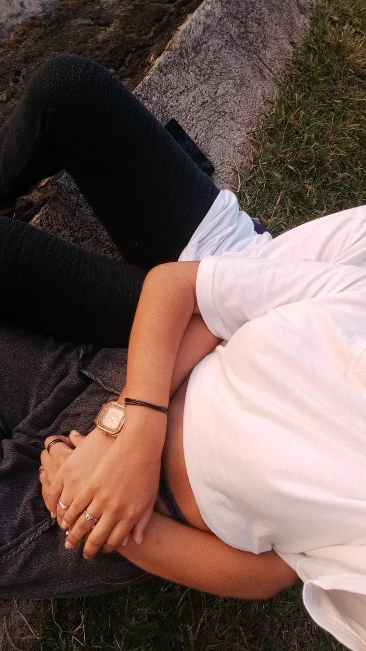 a woman laying on the ground next to a man in white shirt and black pants