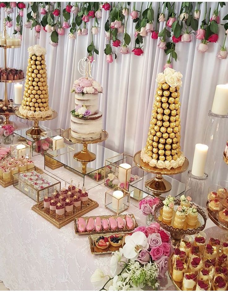 a table topped with lots of cakes and cupcakes